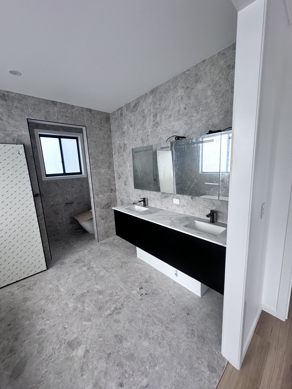 Ensuite bathroom with black double vanity and mirrored cabinets