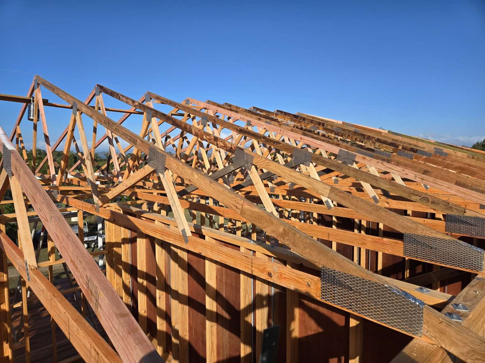 Corner of a new build timber frame under a large open shed