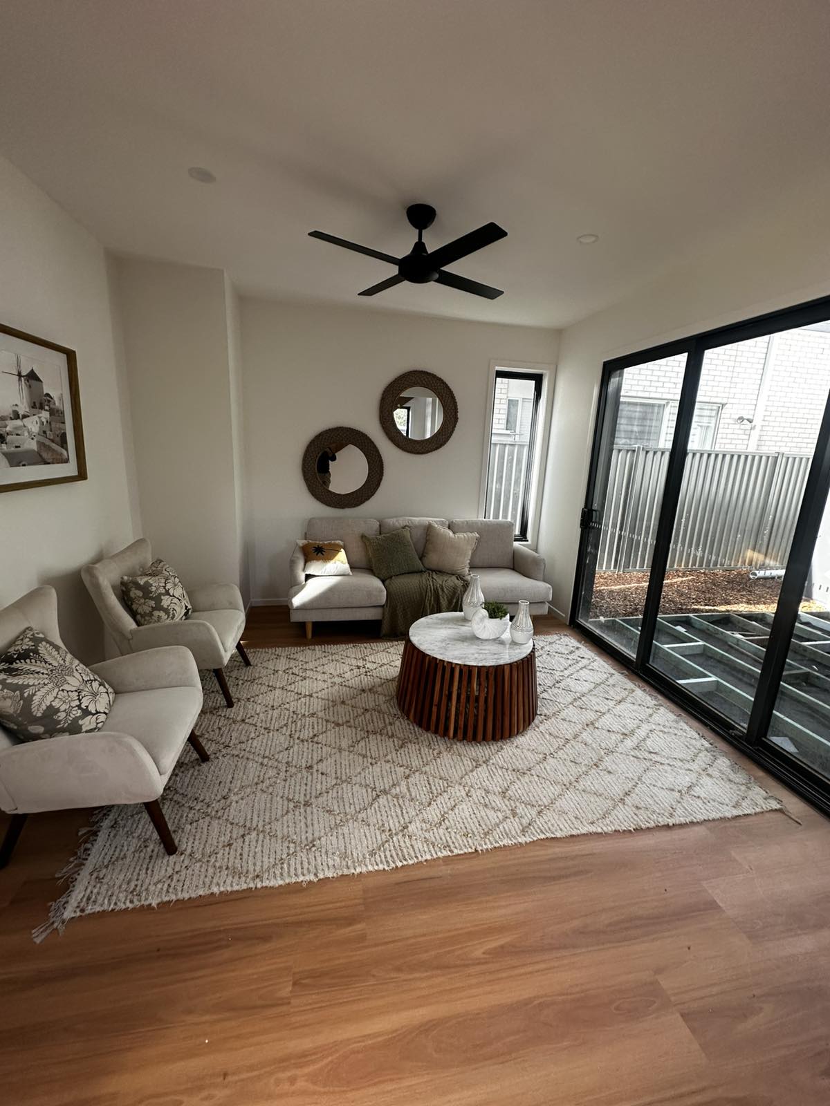 Styled living room with armchairs, rug and sliding door to the backyard